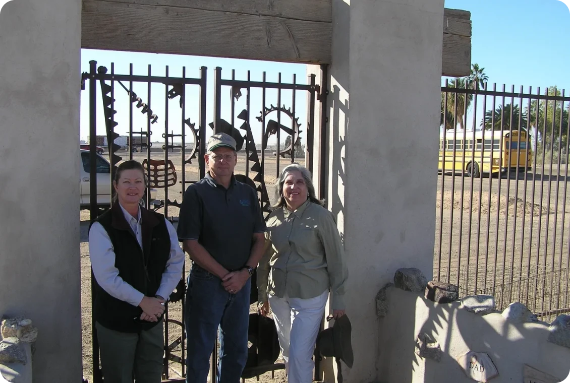 Trio in front of artistic metal gate